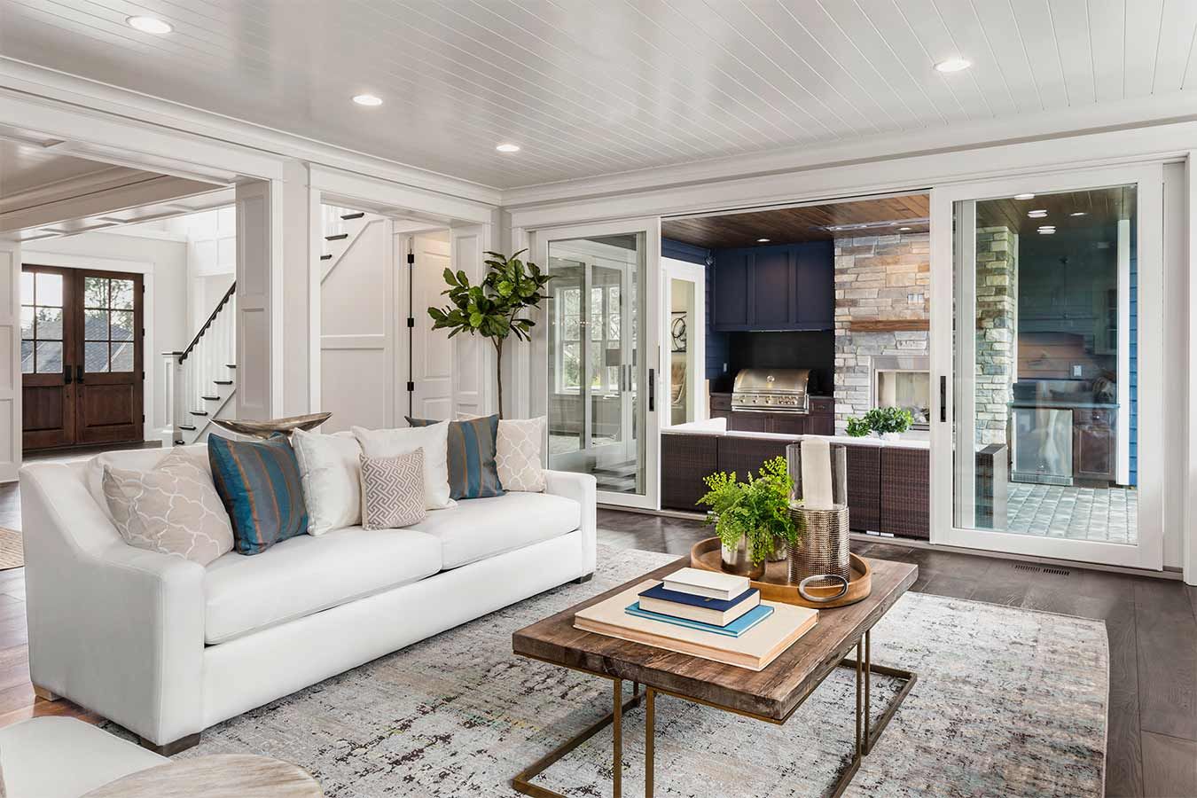 White living room with wide glass patio doors opening to a covered outdoor space